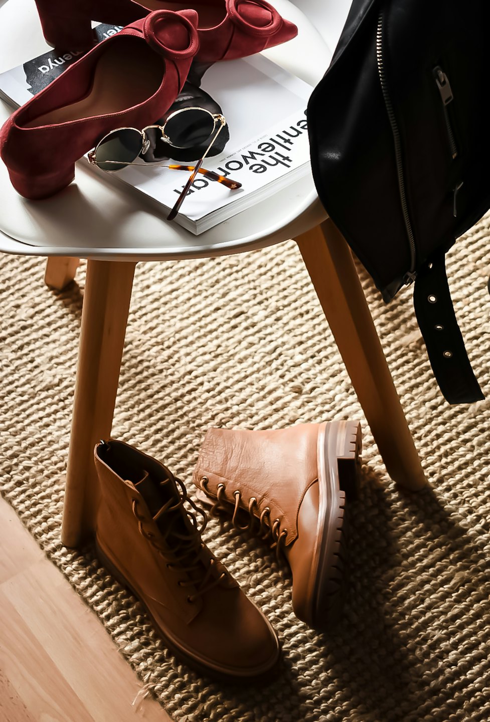 Fashion accessories including red heels and boots on a side table.